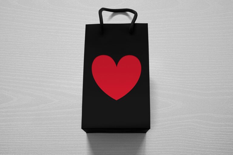 Shopping bag with a heart against white wood